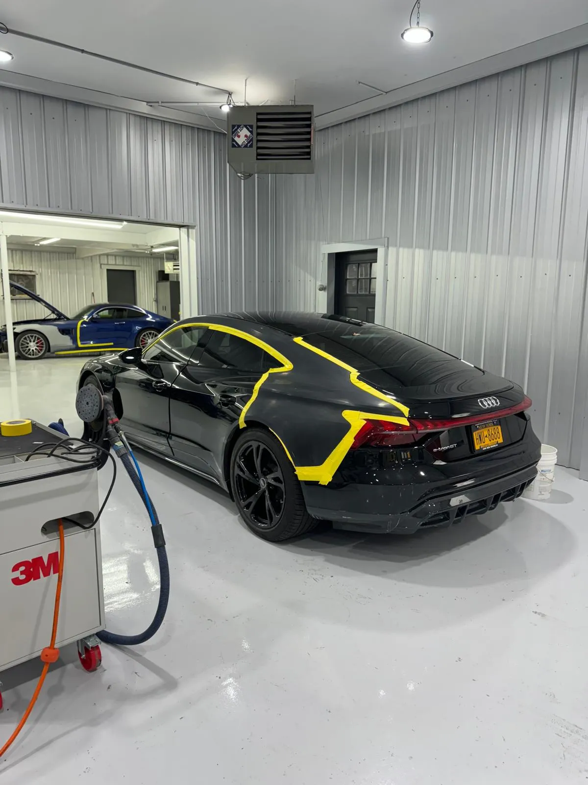 Black e-tron GT taped for spot repair with 3M equipment. EV-safe procedures throughout.