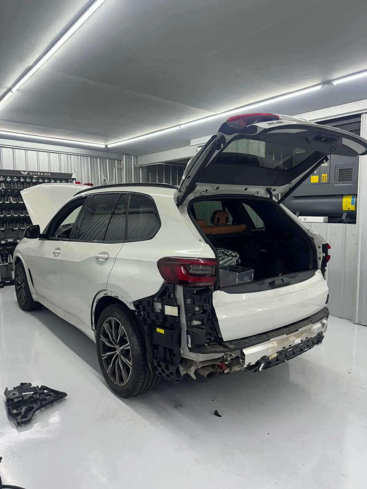 White X5 rear quarter and bumper removal in the paint booth. Preparing for refinish.