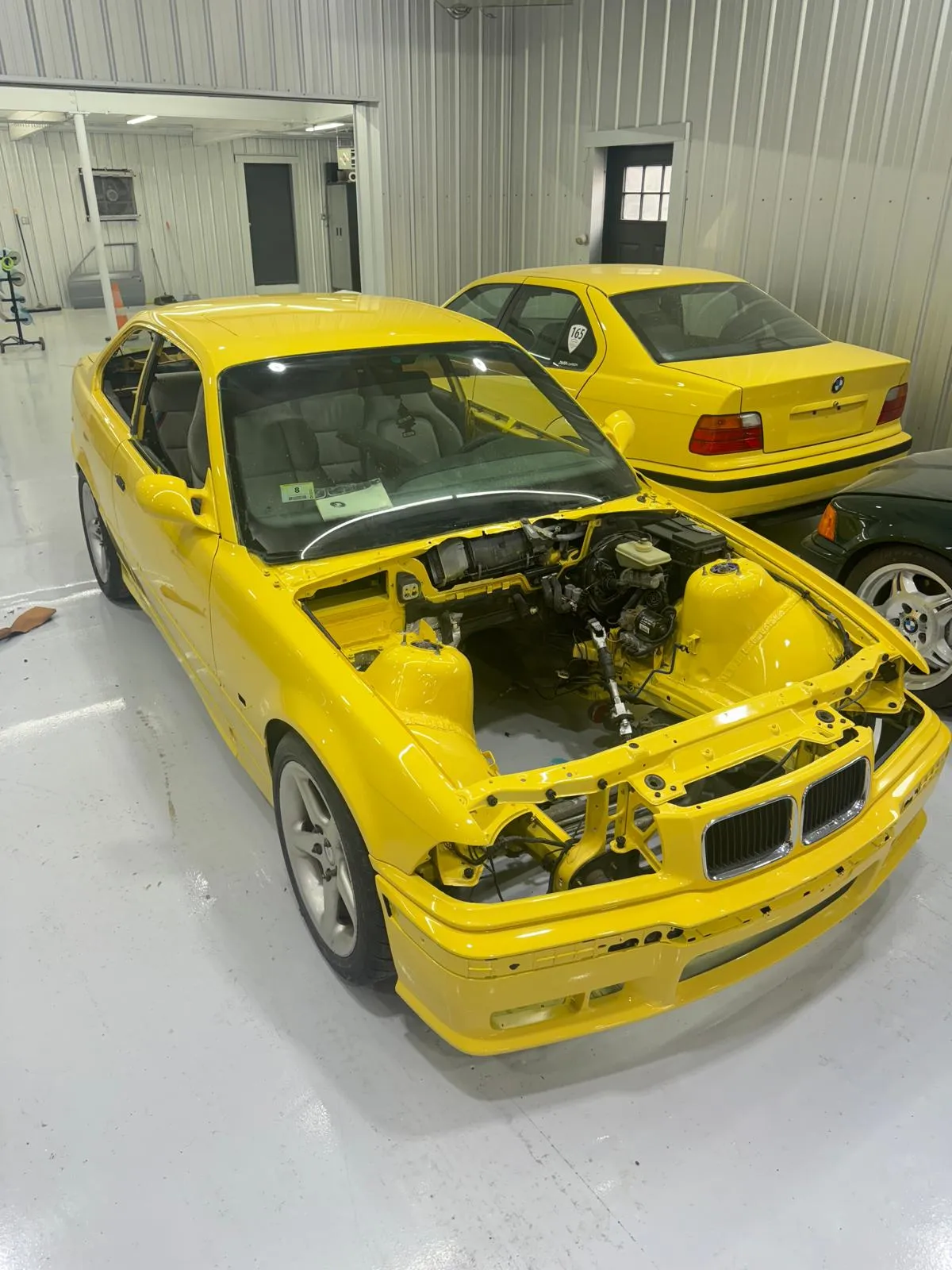 Dakar Yellow E36 M3 pair undergoing full body restoration. Engine-out respray with complete jamb work.
